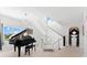 Elegant foyer with a grand piano, modern staircase, and stylish decor at 130 Green Dolphin Dr, Placida, FL 33946