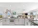 Open-concept kitchen with white cabinets, granite countertops, and an island cooktop at 130 Green Dolphin Dr, Placida, FL 33946
