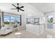 Living room area with white armchair, ceiling fan, and windows offering outdoor views at 130 Green Dolphin Dr, Placida, FL 33946