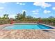 Tranquil pool setting with a brick paver patio, lounge chairs, and fenced yard at 130 Green Dolphin Dr, Placida, FL 33946