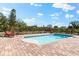 Backyard oasis featuring a sparkling pool, red lounge chairs, and a fenced yard at 130 Green Dolphin Dr, Placida, FL 33946