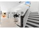 Staircase with black and white steps, piano, and orange accent chair at 130 Green Dolphin Dr, Placida, FL 33946