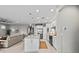 View of the open kitchen with white cabinets, stainless steel appliances, and adjacent living area at 13940 Miranese St, Venice, FL 34293