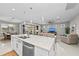 Open-concept kitchen and living area with island, pendant lights, and sliding glass doors to the patio at 13940 Miranese St, Venice, FL 34293