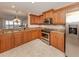 Modern kitchen with stainless steel appliances, wood cabinets, and ample counter space at 157 Tampa E Ave # 807, Venice, FL 34285