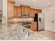 Kitchen featuring stainless steel appliances, wood cabinets, and granite countertops at 157 Tampa E Ave # 807, Venice, FL 34285