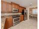 Kitchen with wood cabinets, stainless steel appliances, granite countertops, and an adjacent office nook at 157 Tampa E Ave # 807, Venice, FL 34285