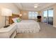 Coastal-themed main bedroom with a king-size bed, ceiling fan, and sliding glass doors to a balcony at 157 Tampa E Ave # 807, Venice, FL 34285