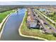 Aerial view of the property showcasing lake, lush landscape and building exteriors at 17118 Vardon Ter # 202, Bradenton, FL 34211