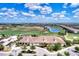 Aerial view of golf course and clubhouse and community with lush trees and landscaping and blue skies at 17118 Vardon Ter # 202, Bradenton, FL 34211