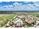 Expansive aerial shot of a clubhouse and pool surrounded by residences, landscaping, and a golf course at 17118 Vardon Ter # 202, Bradenton, FL 34211