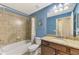 Well-lit bathroom features a tiled shower, bath, and granite countertop vanity at 17118 Vardon Ter # 202, Bradenton, FL 34211