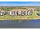 Lakefront condominium with private terraces, mature palm trees, and neatly manicured lawn at 17118 Vardon Ter # 202, Bradenton, FL 34211