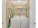 Well-equipped laundry room with washer, dryer, and storage shelves at 17118 Vardon Ter # 202, Bradenton, FL 34211