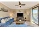Cozy living room with blue sofa, television, and sliding glass doors to the patio at 17118 Vardon Ter # 202, Bradenton, FL 34211