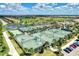 Aerial view of many tennis courts with lush landscaping and blue skies in a residential neighborhood at 17118 Vardon Ter # 202, Bradenton, FL 34211