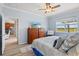 Main bedroom with wooden furniture, ceiling fan, and attached bathroom at 19225 Jacinda St, Venice, FL 34293