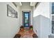 Front entry with a blue door, red flowers, and terracotta tile at 19279 Jacinda St, Venice, FL 34293