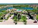 Community entrance with palm trees and a large clubhouse featuring a pool at 20100 Ragazza Cir # 101, Venice, FL 34293