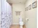 Simple bathroom with neutral walls, white toilet, and shower with patterned curtain at 20100 Ragazza Cir # 101, Venice, FL 34293