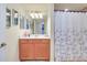Clean guest bathroom featuring orange cabinets, white countertop, and a shower at 20100 Ragazza Cir # 101, Venice, FL 34293