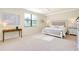 Spacious bedroom with a king-size bed, ceiling fan, and carpeted floors at 20100 Ragazza Cir # 101, Venice, FL 34293