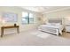 Spacious bedroom with a king-size bed, ceiling fan, and carpeted floors at 20100 Ragazza Cir # 101, Venice, FL 34293