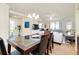 Open-concept dining area adjacent to the living room, showcasing a sleek glass-top table, leather chairs, and access to the front entry at 20100 Ragazza Cir # 101, Venice, FL 34293