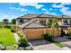 Two-story townhome with tile roof, attached two-car garage, and lush landscaping under a bright blue sky at 20100 Ragazza Cir # 101, Venice, FL 34293