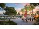 Outdoor plaza with food trucks, seating, and palm trees at sunset at 20100 Ragazza Cir # 101, Venice, FL 34293