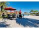 Poolside seating area with tables, umbrellas, and lounge chairs at 20100 Ragazza Cir # 101, Venice, FL 34293