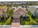 Aerial view of single-Gathering home with tile roof, two-car garage, and paver driveway at 2049 Mesic Hammock Way, Venice, FL 34292