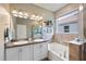 Bathroom with double sinks, granite countertop, soaking tub, and separate shower at 2049 Mesic Hammock Way, Venice, FL 34292