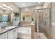 Main bathroom with soaking tub, walk-in shower, and granite vanity at 2049 Mesic Hammock Way, Venice, FL 34292