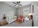 Bedroom with crib, armchair, and built-in shelves at 2049 Mesic Hammock Way, Venice, FL 34292
