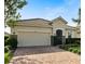 Tan single-Gathering home with tile roof, two-car garage, and paver driveway at 2049 Mesic Hammock Way, Venice, FL 34292