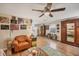 Cozy living room with hardwood floors, ceiling fan, vintage furniture, and an eclectic art collection at 2191 Park Rd, Venice, FL 34293