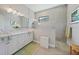 Modern bathroom featuring a double vanity, a tiled shower, and neutral color palette at 26069 Norman Dr, Englewood, FL 34223