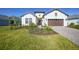 Beautifully landscaped home with a two-car garage and charming front yard at 26069 Norman Dr, Englewood, FL 34223