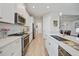 Modern kitchen featuring white cabinetry, stainless steel appliances, and sleek countertops at 26069 Norman Dr, Englewood, FL 34223