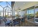 Outdoor dining on a screened in lanai with elegant wrought iron chairs at 26069 Norman Dr, Englewood, FL 34223
