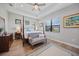 Inviting main bedroom features a four-poster bed, tray ceiling, and bright windows at 26069 Norman Dr, Englewood, FL 34223