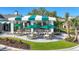 Outdoor seating area with tables and chairs under a covered patio with views of a well-maintained lawn at 26069 Norman Dr, Englewood, FL 34223