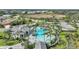 Aerial view of a community pool, surrounded by palm trees and lush landscaping with view of a lake nearby at 26069 Norman Dr, Englewood, FL 34223