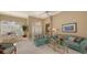 Open living space with teal sofas, and view of dining area at 275 Royal Oak Way, Venice, FL 34292