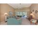 Living area featuring teal sofa, access to patio, and natural light at 275 Royal Oak Way, Venice, FL 34292