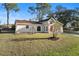 Tan house with red door, landscaping, and driveway at 2972 Crane Ave, North Port, FL 34286