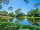 Tranquil pond with wooden footbridge and reflecting trees at 3667 Yellow Pine Ct # 149, Sarasota, FL 34238