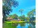 Peaceful pond with a scenic wooden bridge, lush greenery, and a pool in the background at 3667 Yellow Pine Ct # 149, Sarasota, FL 34238