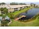 Dock on a pond with surrounding buildings and trees at 380 Three Lakes Ln # E, Venice, FL 34285